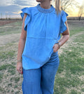 Blue denim Sterling Kreek ruffle sleeve shirt.