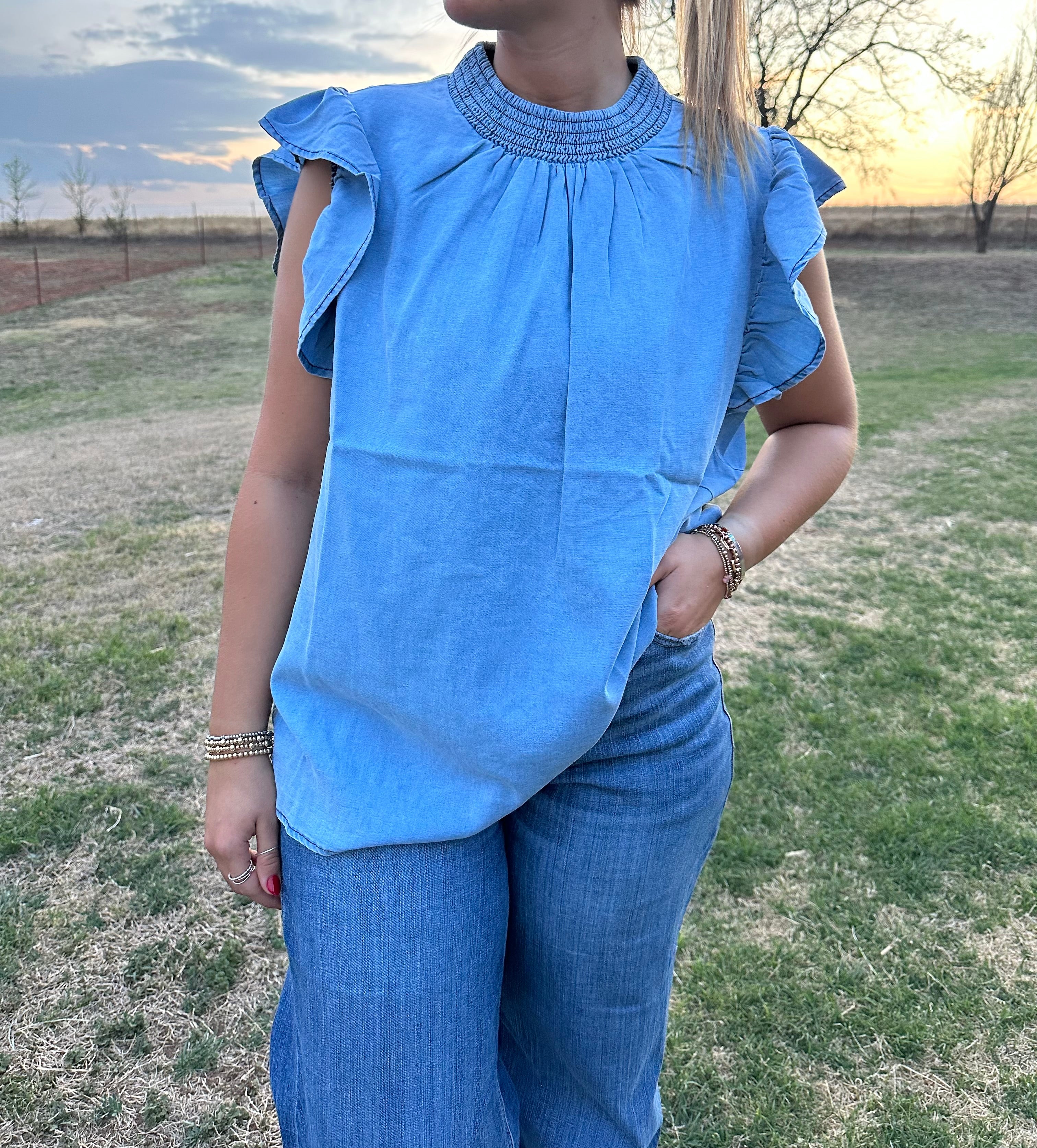 Blue denim Sterling Kreek ruffle sleeve shirt.